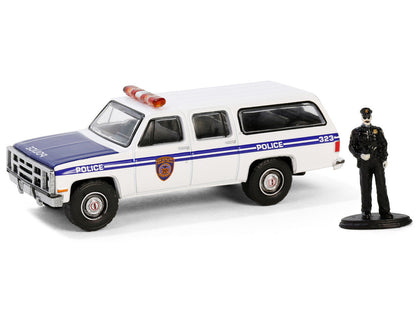 1985 GMC Suburban 2500 "New York City Transit Police Department" White with Blue Stripes and Police Officer Figure "The Hobby Shop" Series 16 1/64 Diecast Model Car by Greenlight-0